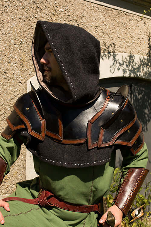 Leather Armor Shoulders & Neck featuring a warrior in a green tunic wearing black leather shoulder armor and a hood.