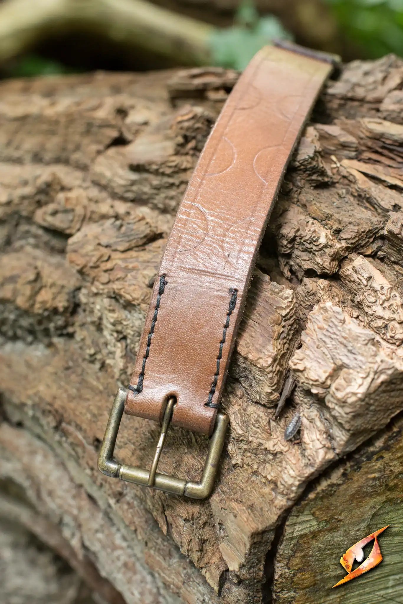 Aruthian Belt displayed on a rustic wooden log, showcasing its sturdy leather design and brass buckle.