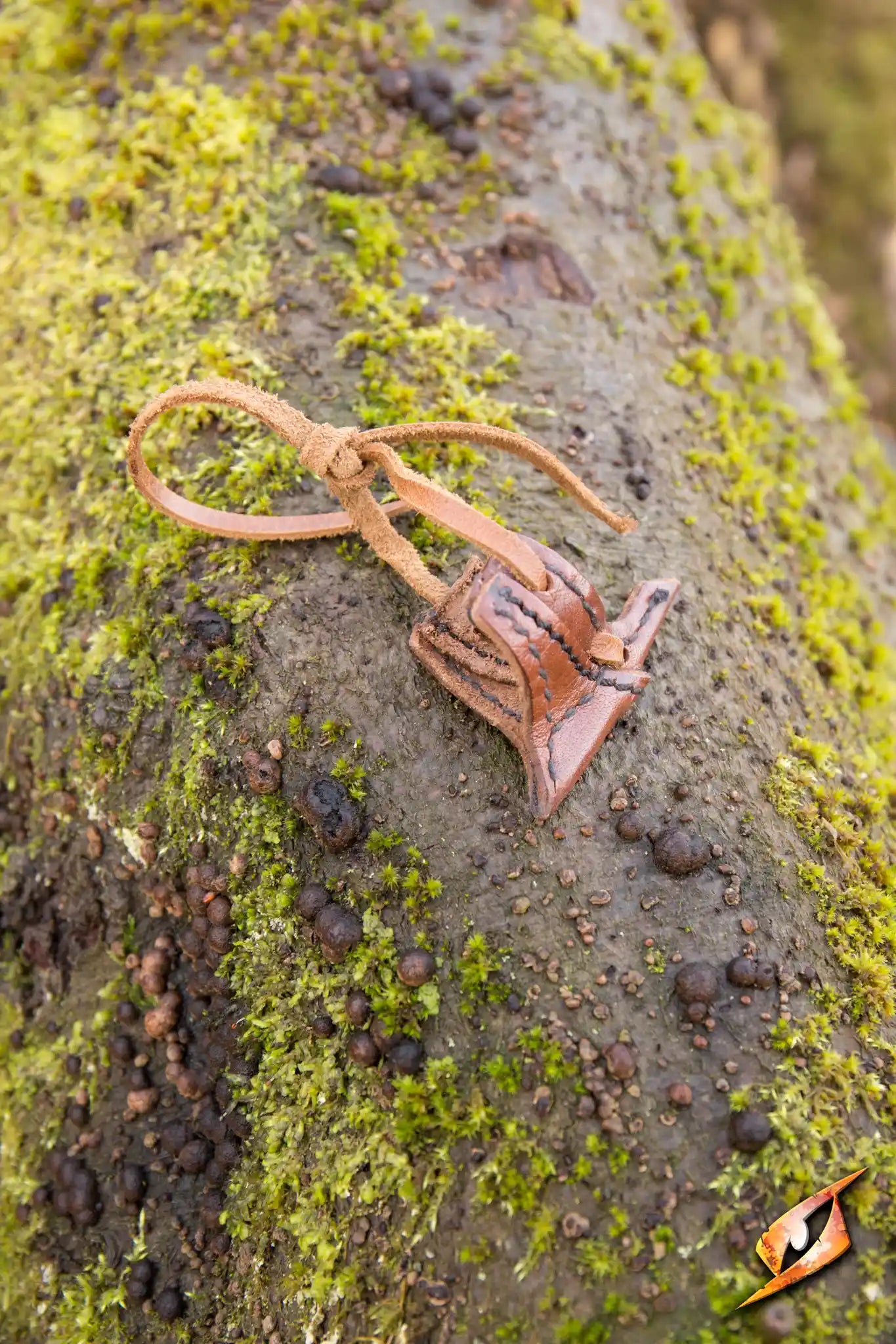 Elven Holster Hook displayed on a mossy tree, showcasing its unique design for securing swords.