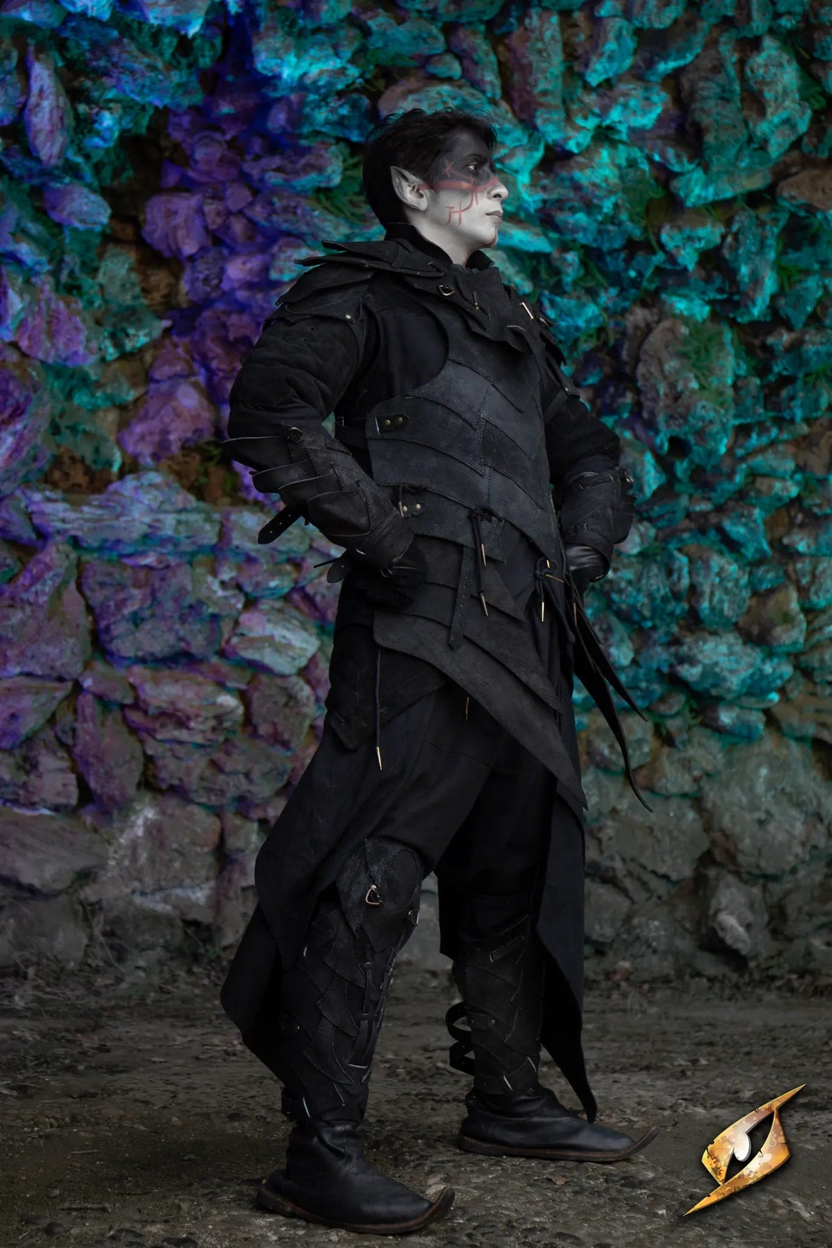 Person wearing the Shadow Armour Set - Suede, standing against a colorful rocky background.
