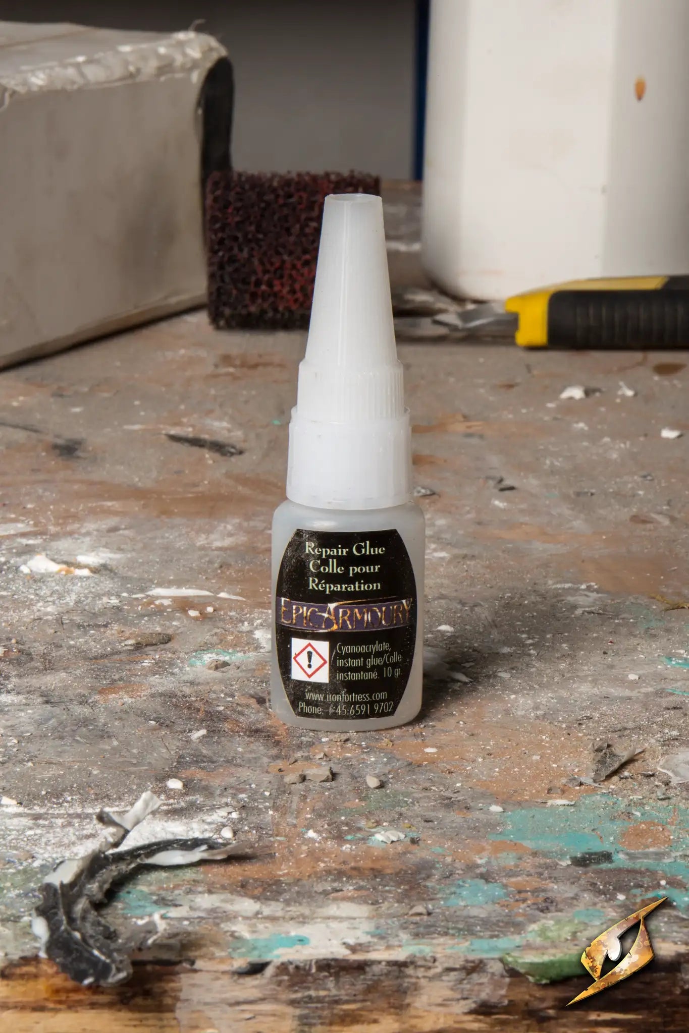 Repair Glue - Sword & Shield 10 g bottle on a workbench, ideal for LARP foam weapon maintenance.