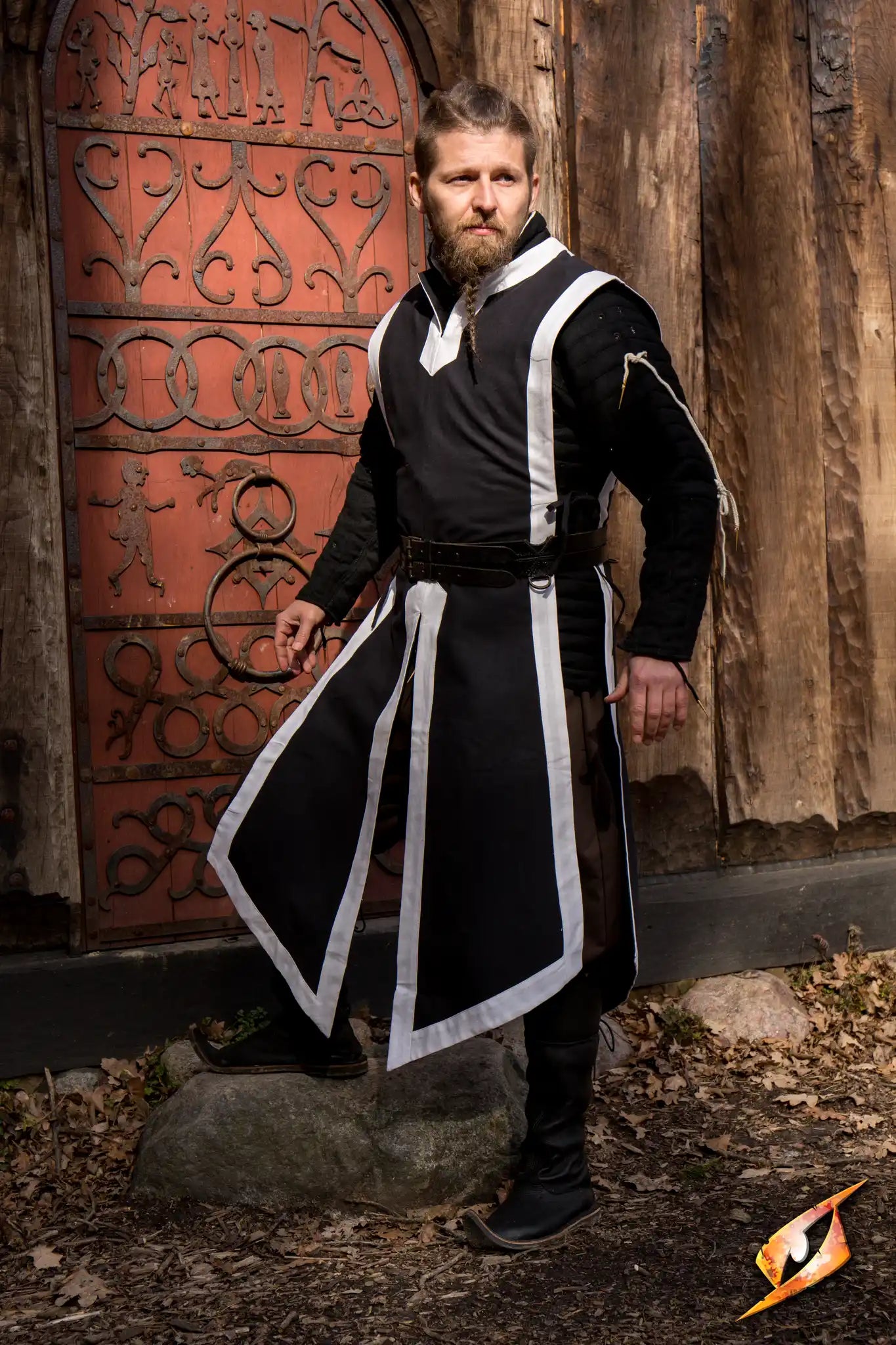 Basic Tabard worn by a knight standing confidently outside a rustic building.