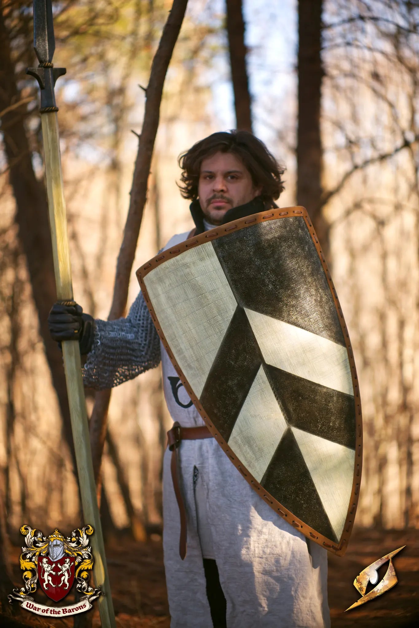 A warrior holding the Baron's Shield, a historical heater-style shield designed for LARP and inspired by medieval heraldry.