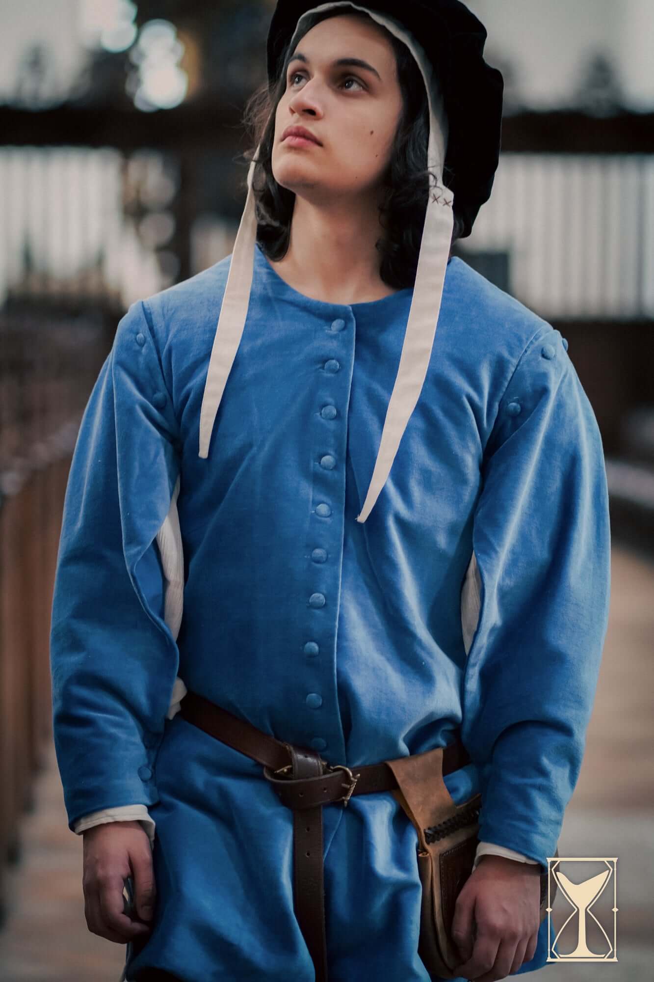 Model wearing a blue Velvet Surcoat, showcasing its medieval design and rich fabric details.