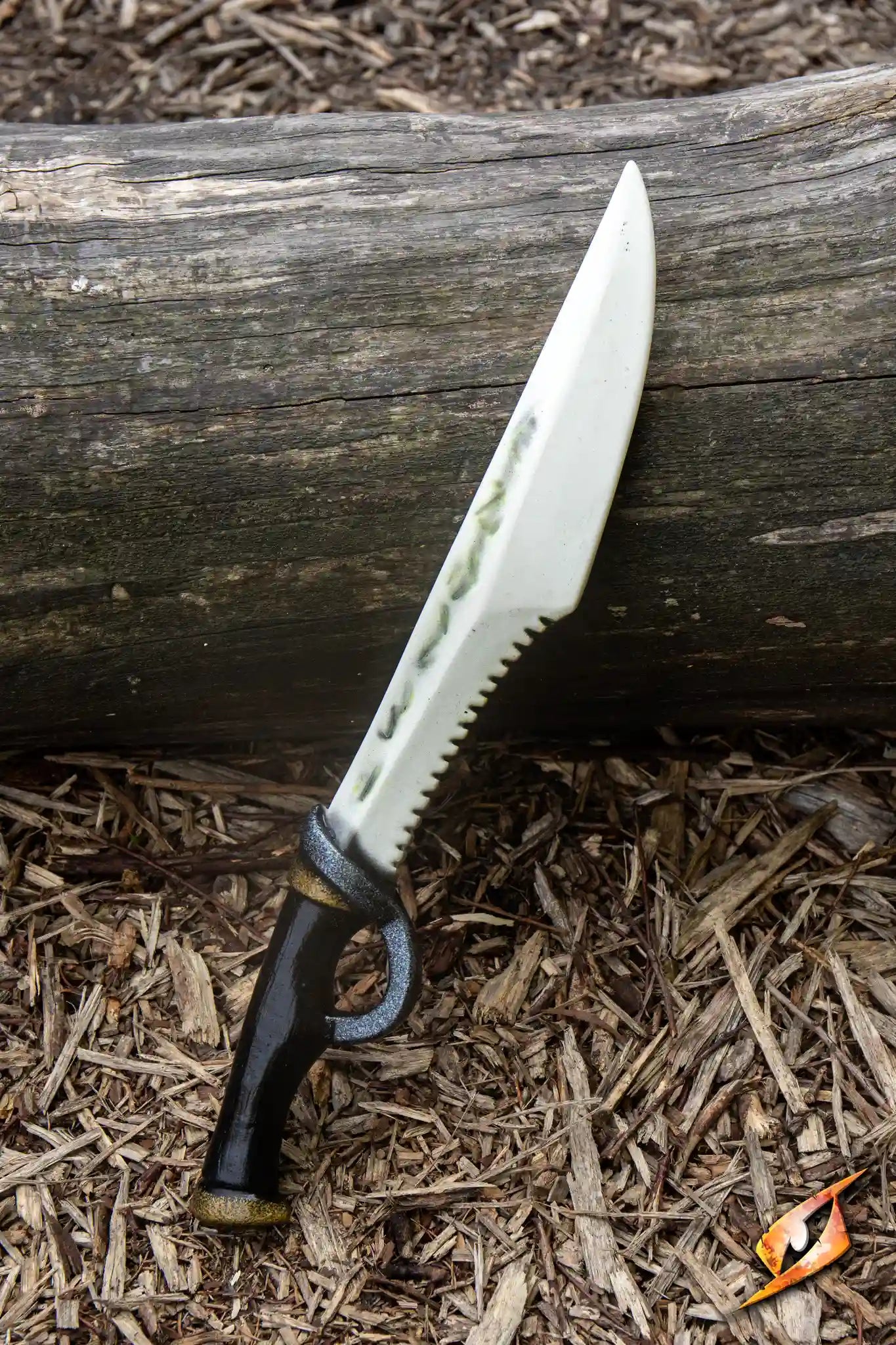 Bone Dagger - 46 cm displayed on a log with a detailed white blade and black handle.