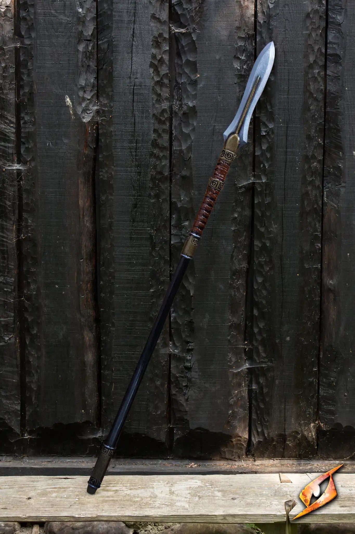 Ancient Spear standing against a rustic wooden backdrop, showcasing its sharp blade and detailed handle.