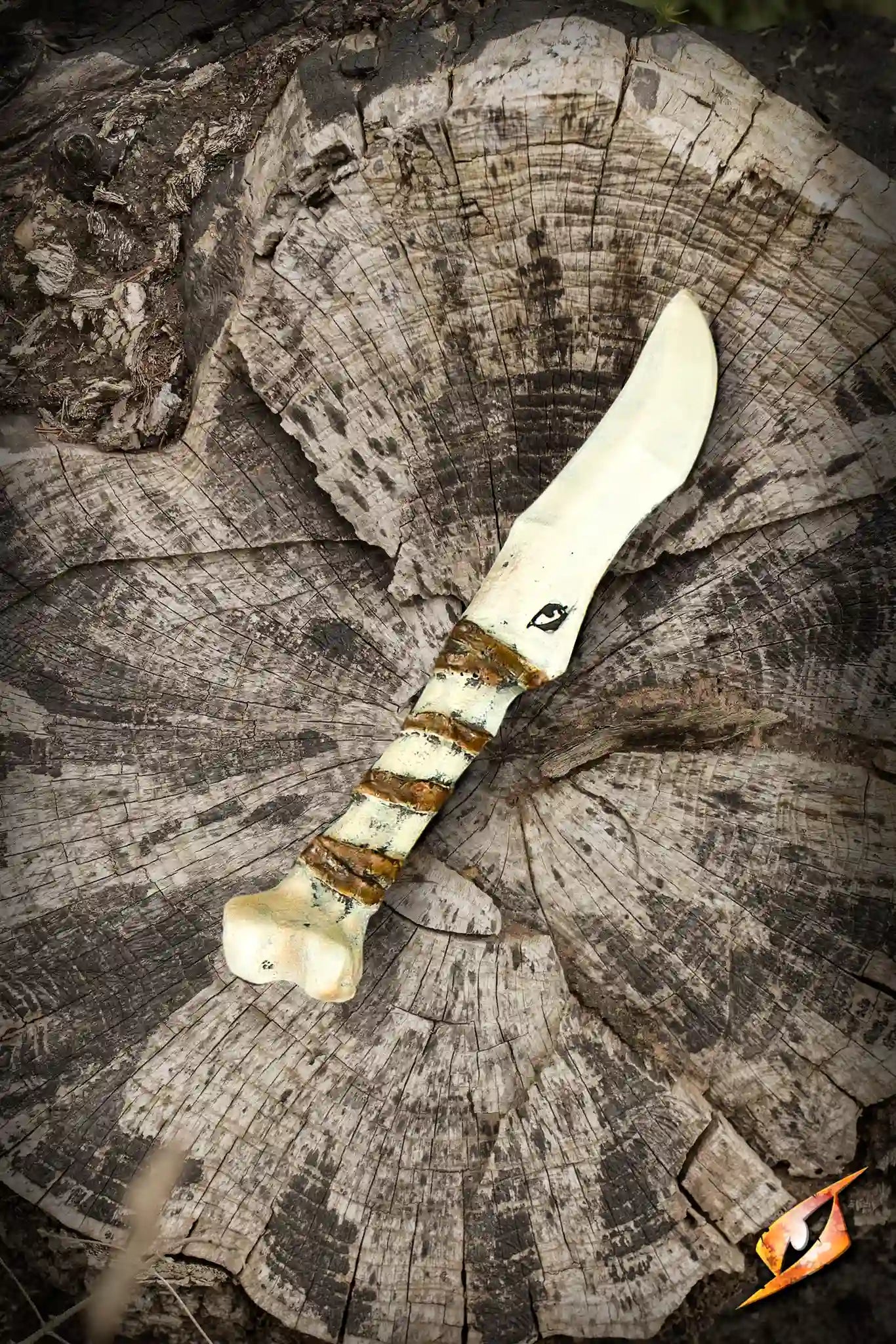 Bone Knife - 21 cm resting on a tree stump, showcasing a realistic bone texture and sculpted handle.