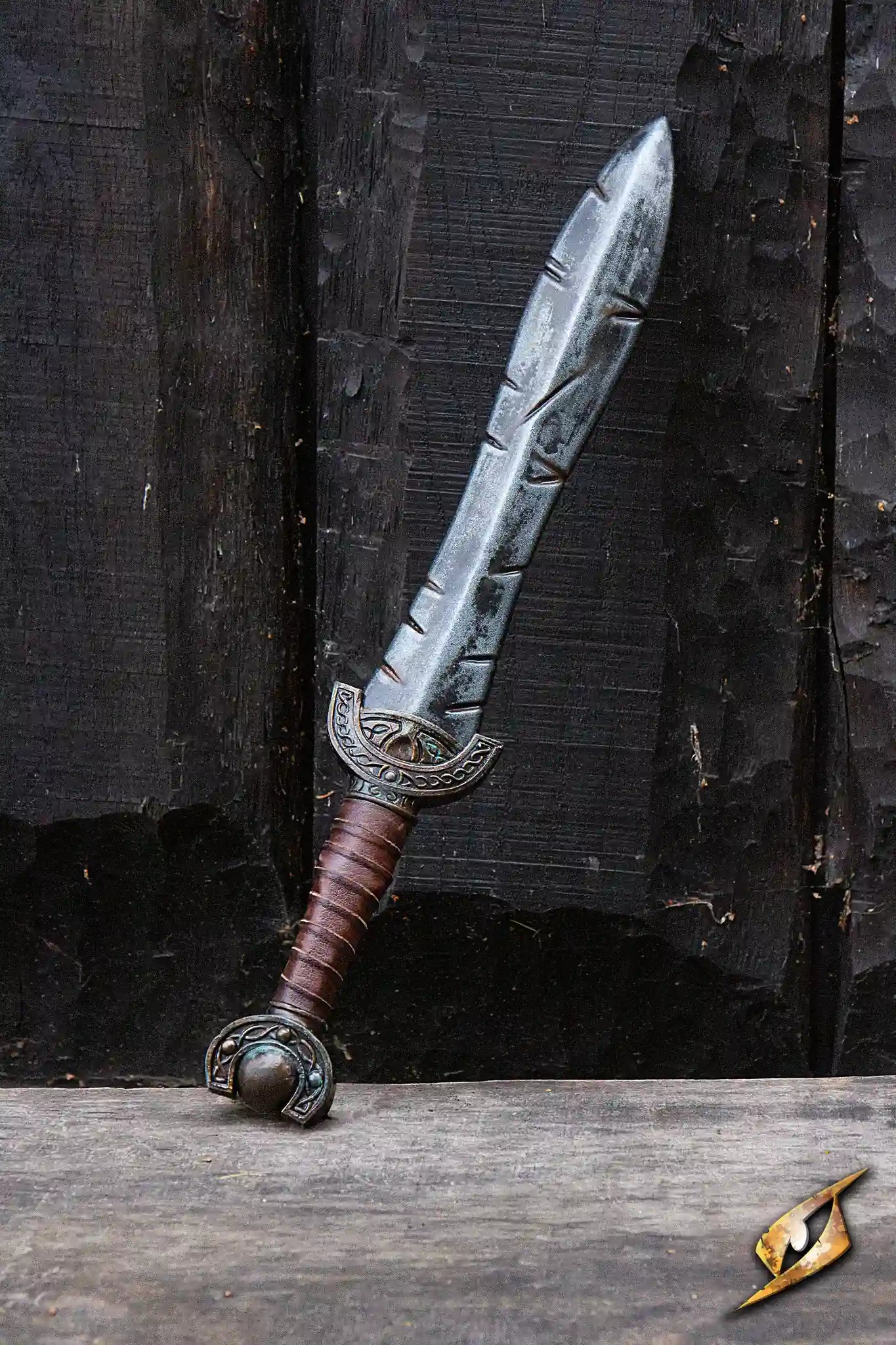 Battleworn Celtic Leaf Sword displayed against a wooden background, showcasing its aged, battle-worn details.