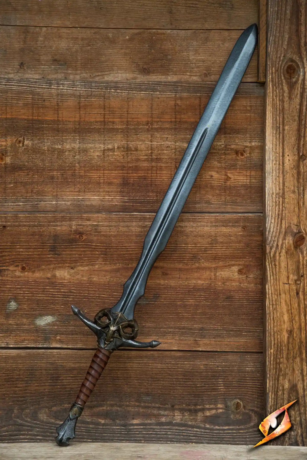 Caprine Sword displayed against a wooden background, featuring a latex blade and a brass ram hilt.
