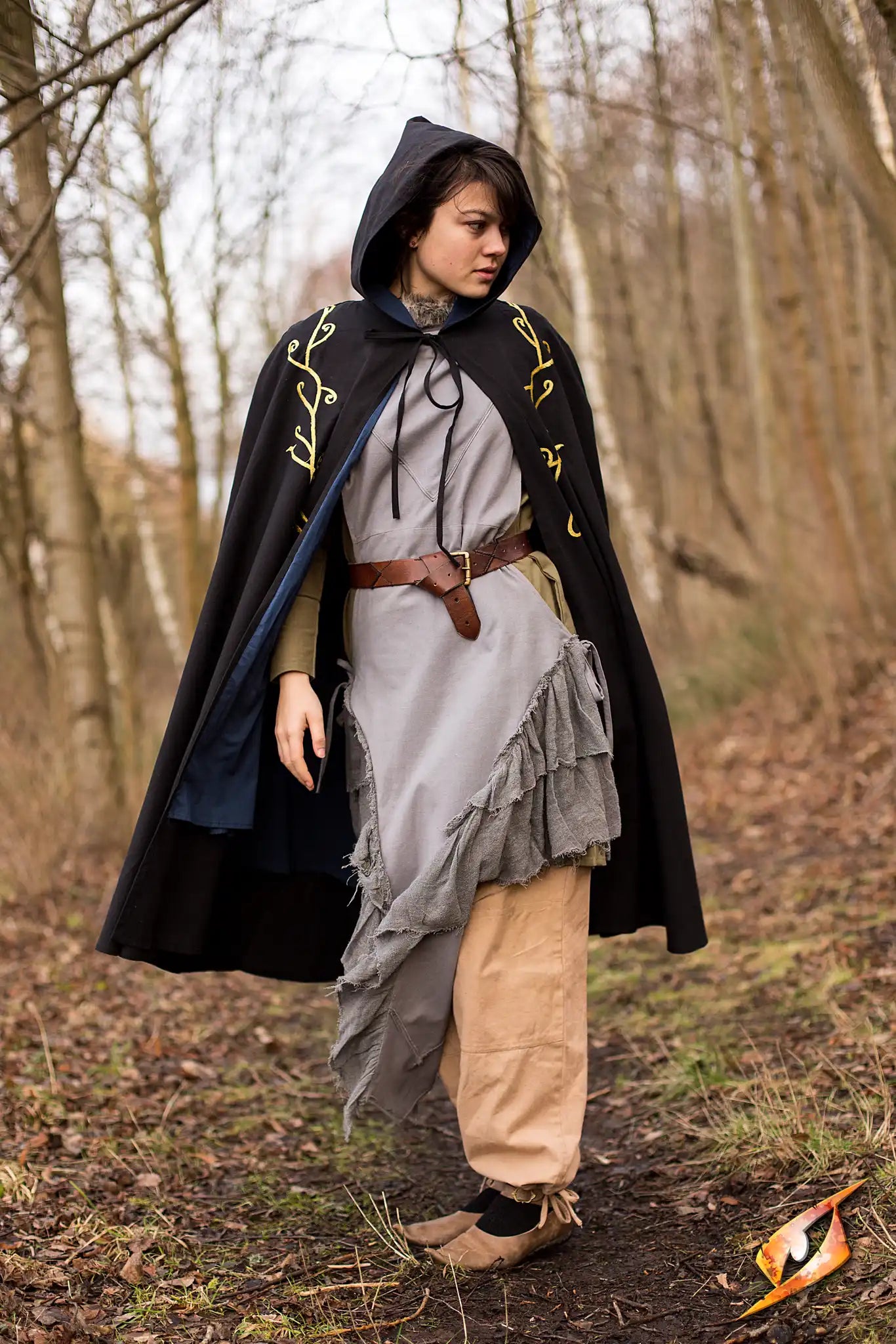 Cape Excl. model wearing the beautifully adorned Epic Armouryās Cape Exclusive in a forest setting.