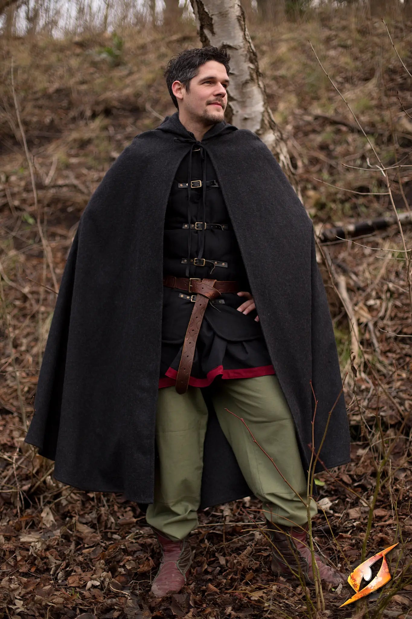 A person wearing a Cape Wool cape, standing confidently in a natural setting, demonstrating warmth and style.