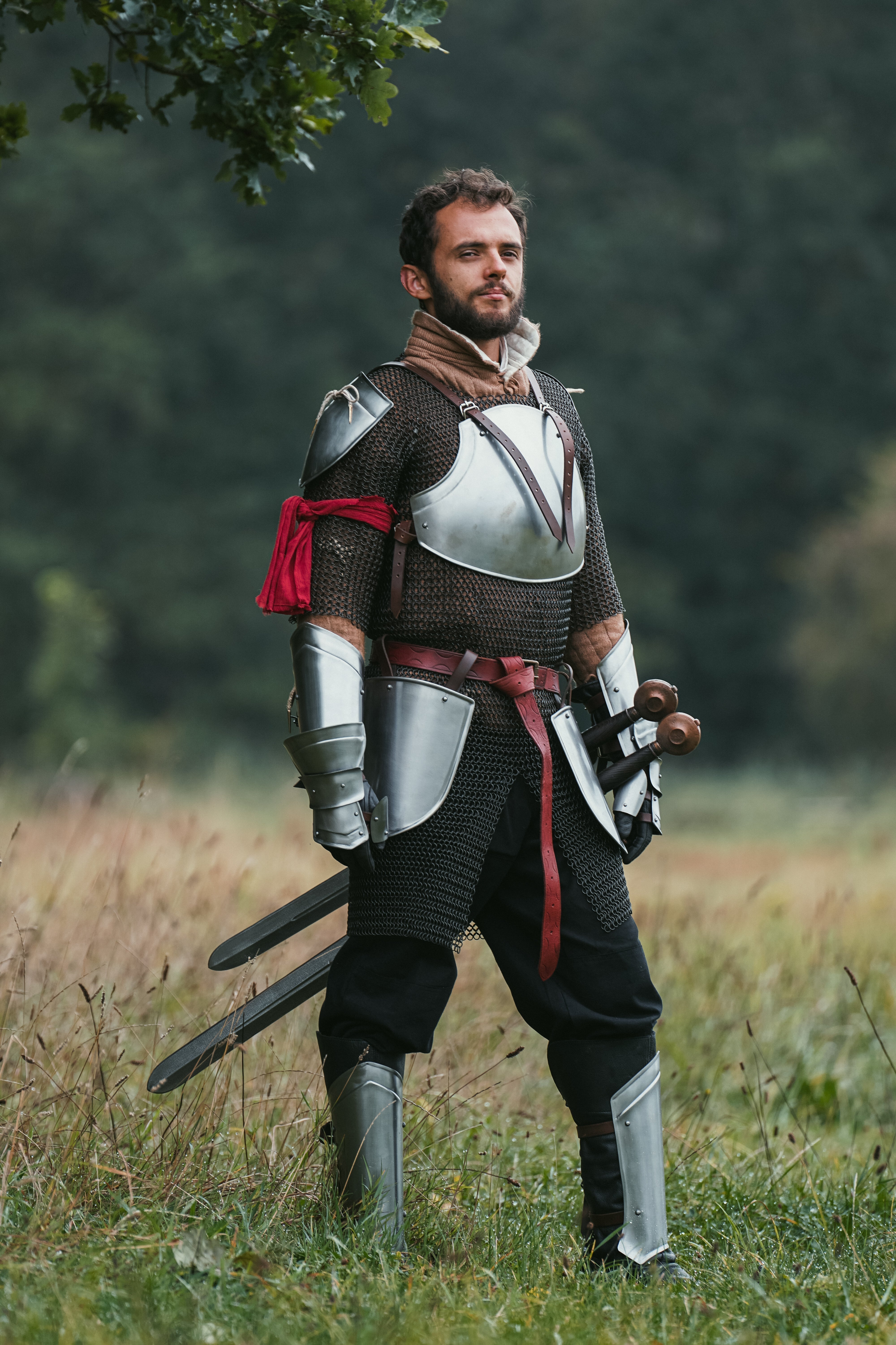 How to Care for Your LARP Gear: LARP character in armor standing in a field with swords.