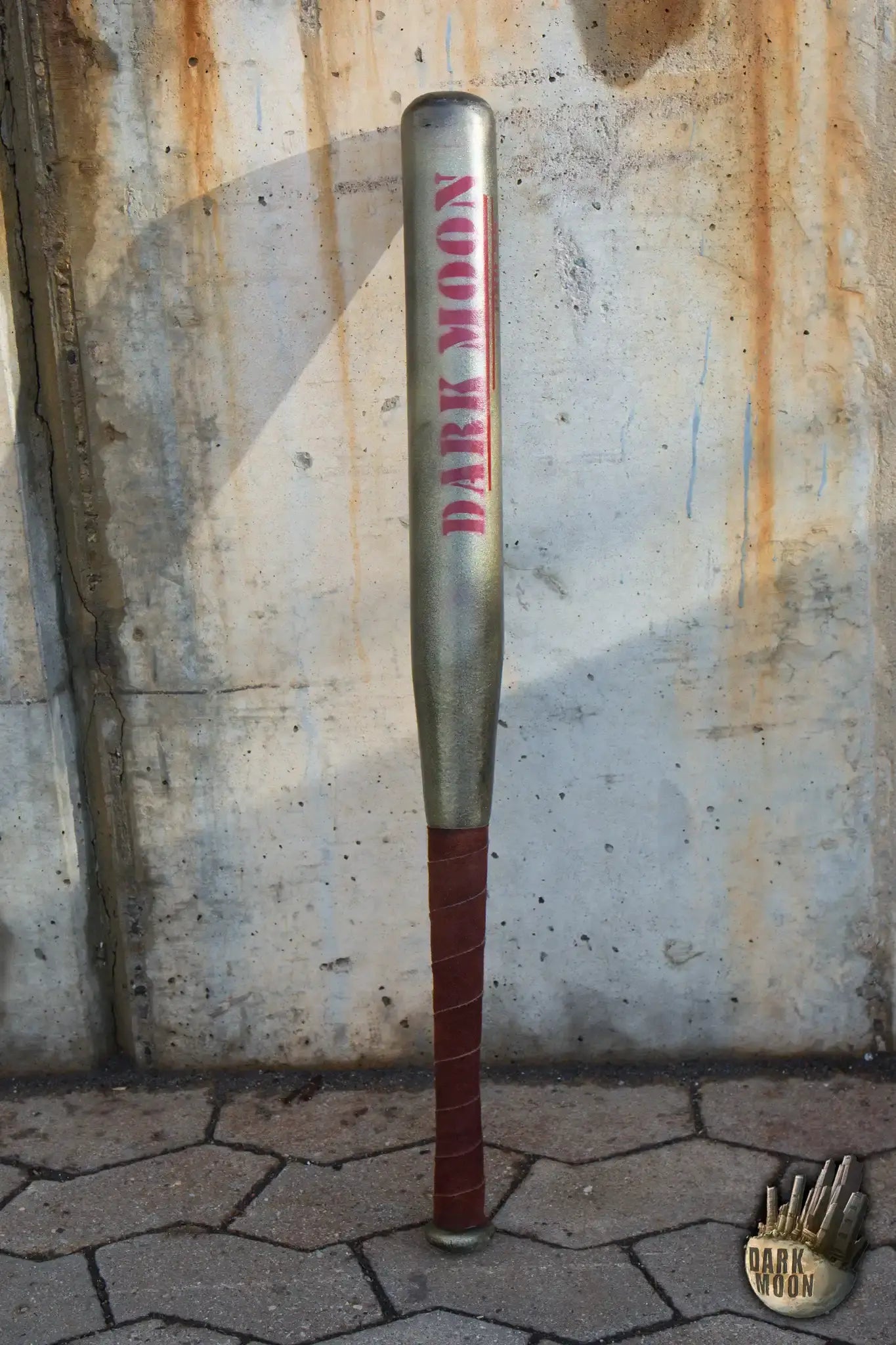 Dark Moon baseball bat displayed against a rustic wall with the name Dark Moon prominently featured.