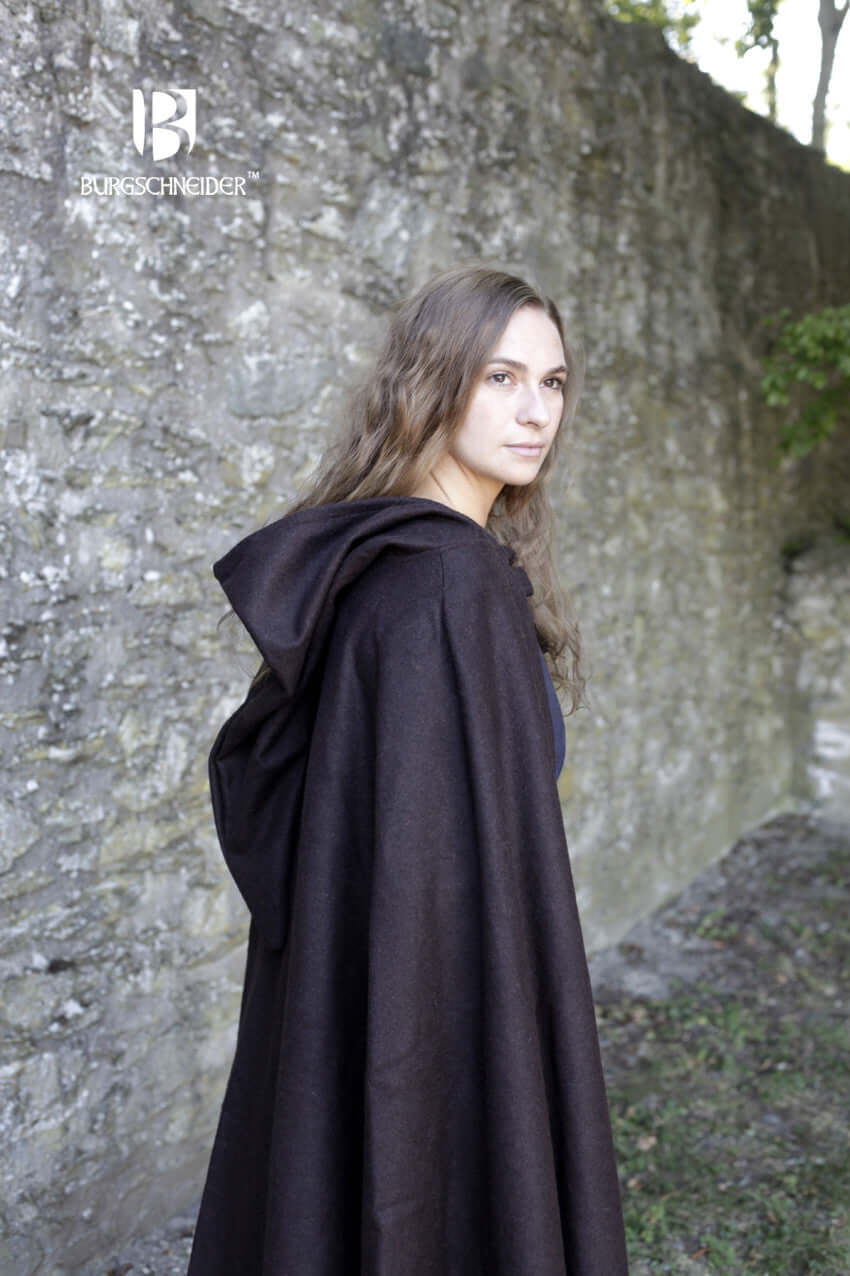 Model wearing the Wool Hooded Cloak Hibernus by Burgschneider, showcasing its brown color and medieval design.