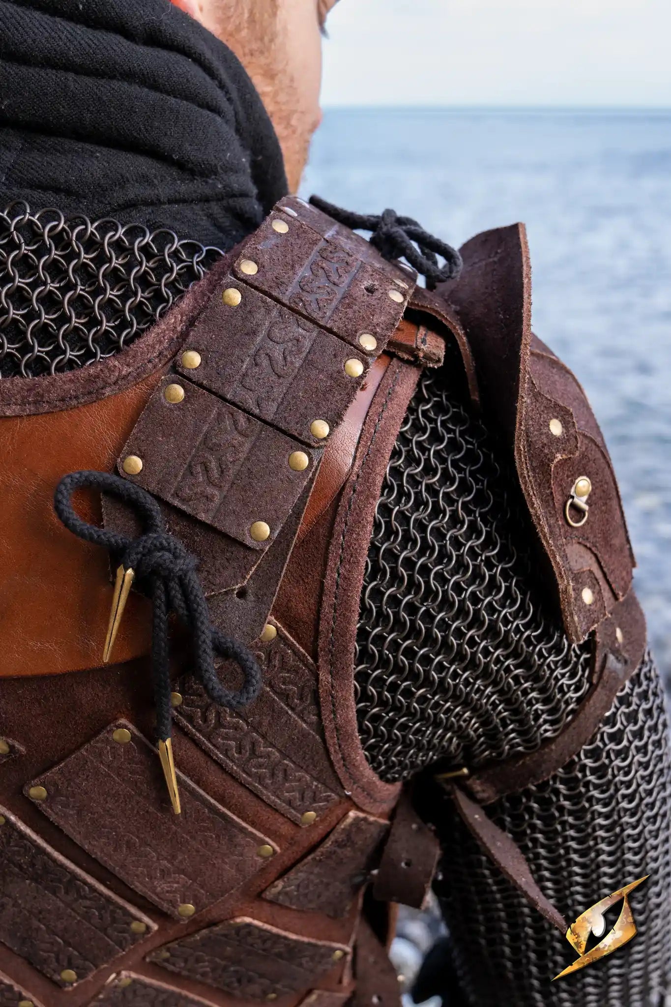 Woodsman Suede Shoulder Armour displayed on LARP character against an outdoor backdrop featuring chainmail and leather armor.