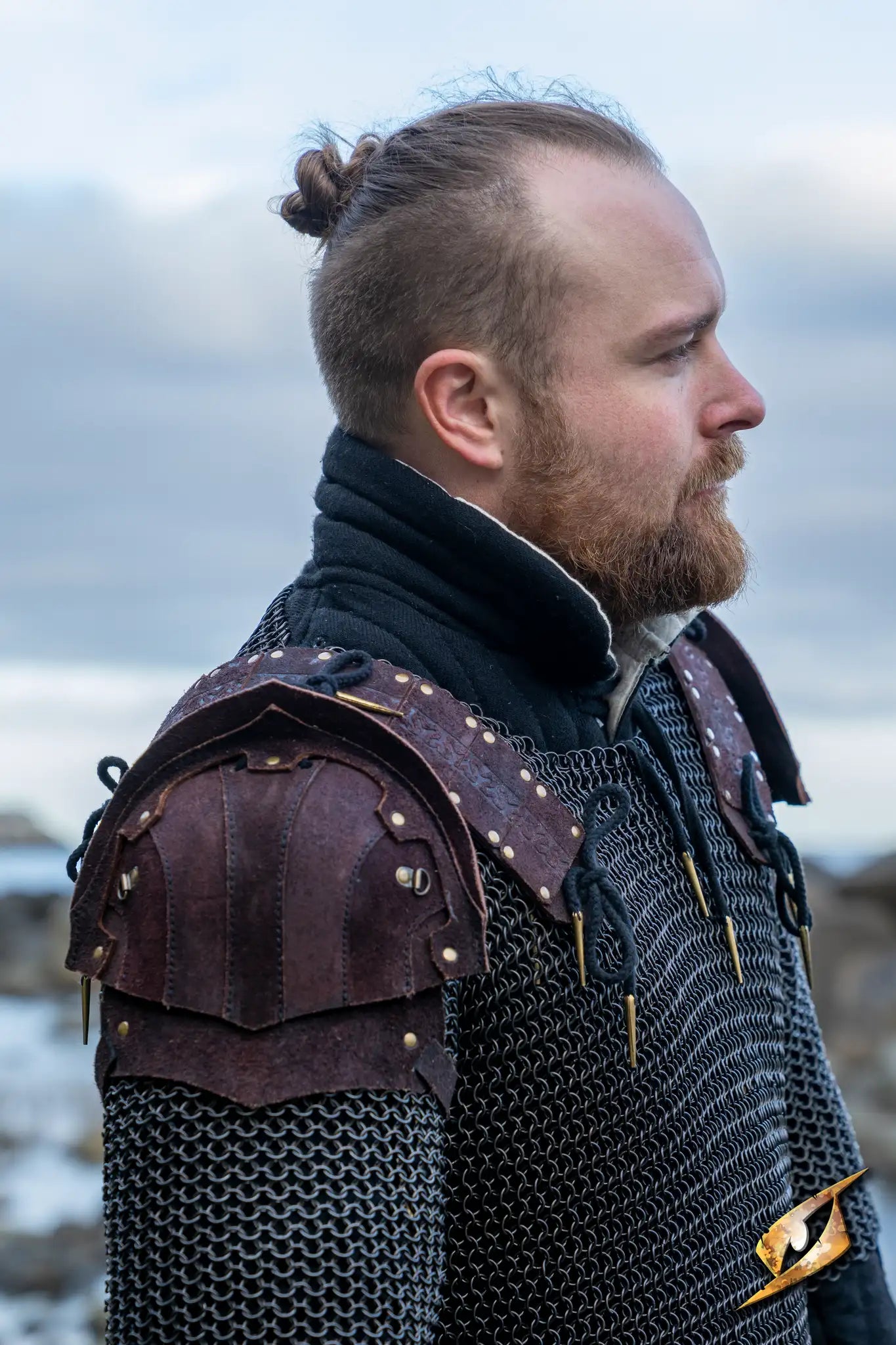 Woodsman Suede Shoulder Armour worn by a man, showcasing detailed leather design and chainmail in an outdoor setting.