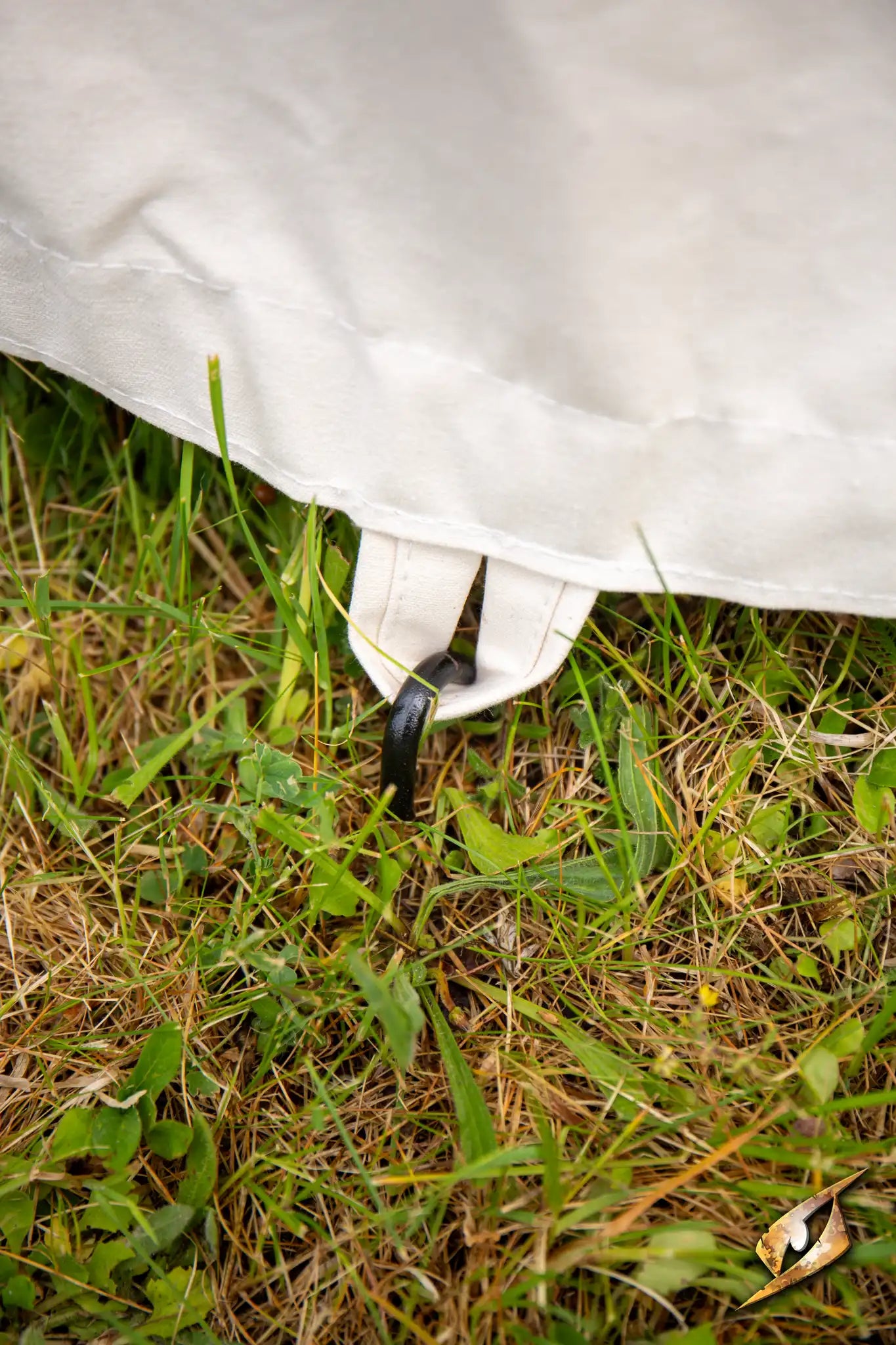 Iron Pins securing a tent fabric to the ground, ensuring stability in outdoor conditions.