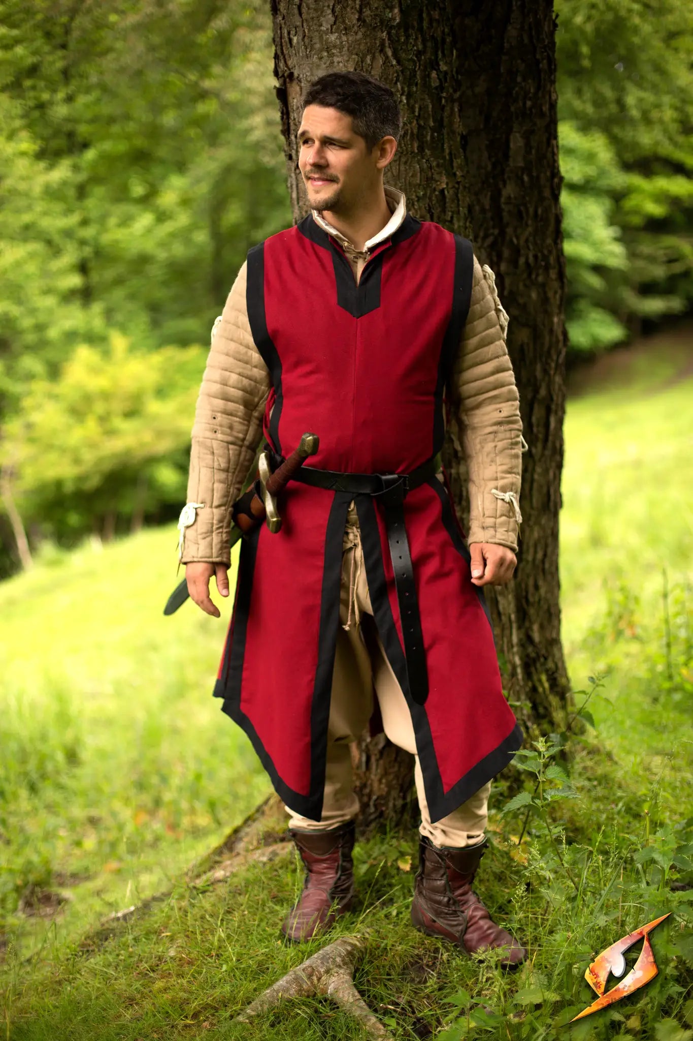 A person wearing a classic red Basic Tabard, standing confidently in a forest setting, ready for adventure.