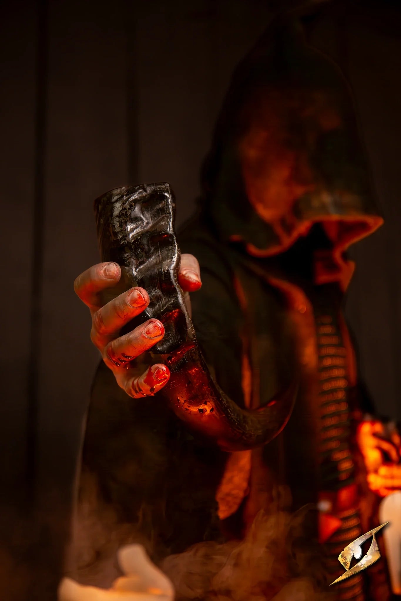 A cloaked figure holding a Ritualistic Drinking Horn, shrouded in an eerie glow and atmospheric smoke.