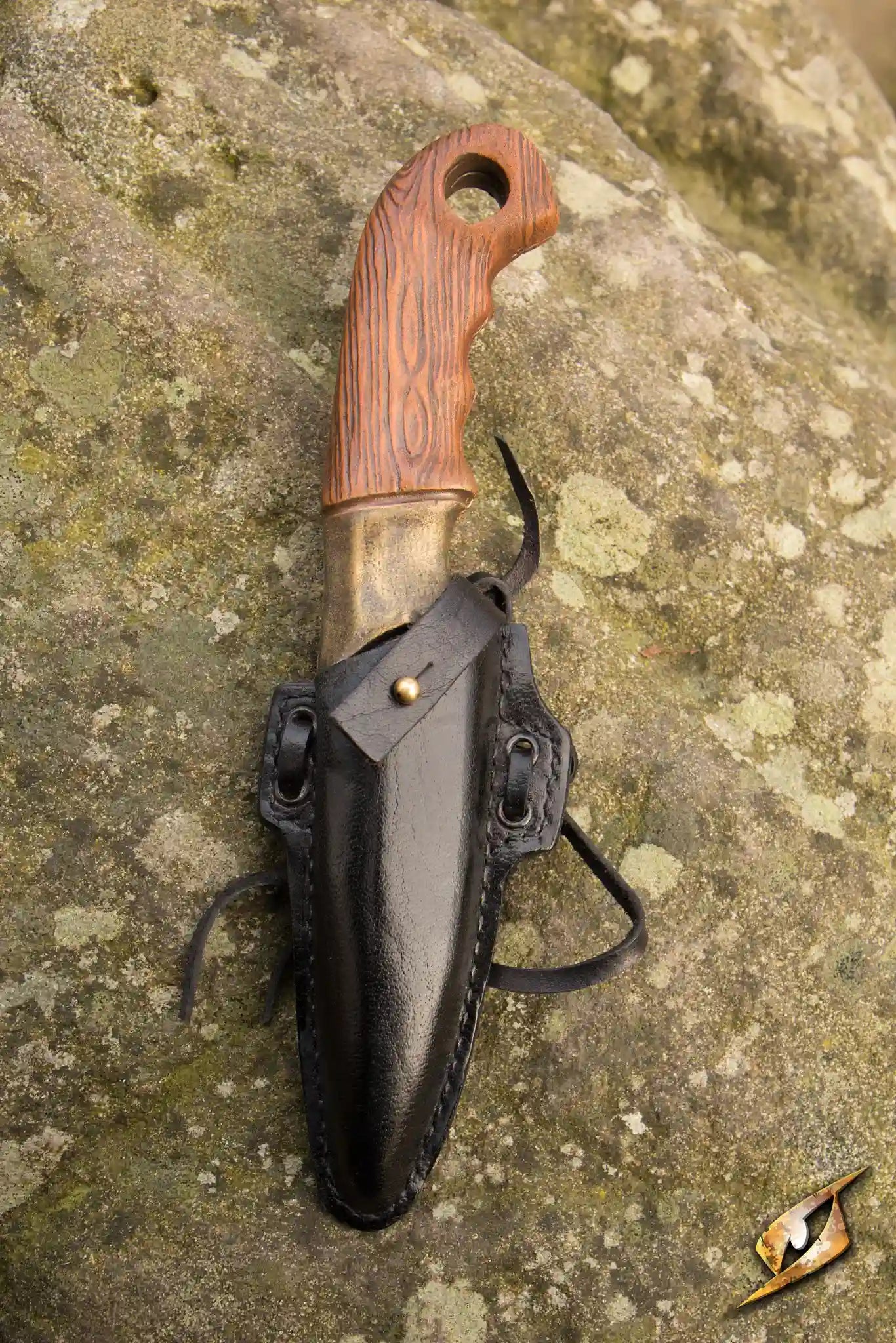 Woodsman Knife & Holder featuring a handcrafted knife secured in a black leather holder against a rocky background.
