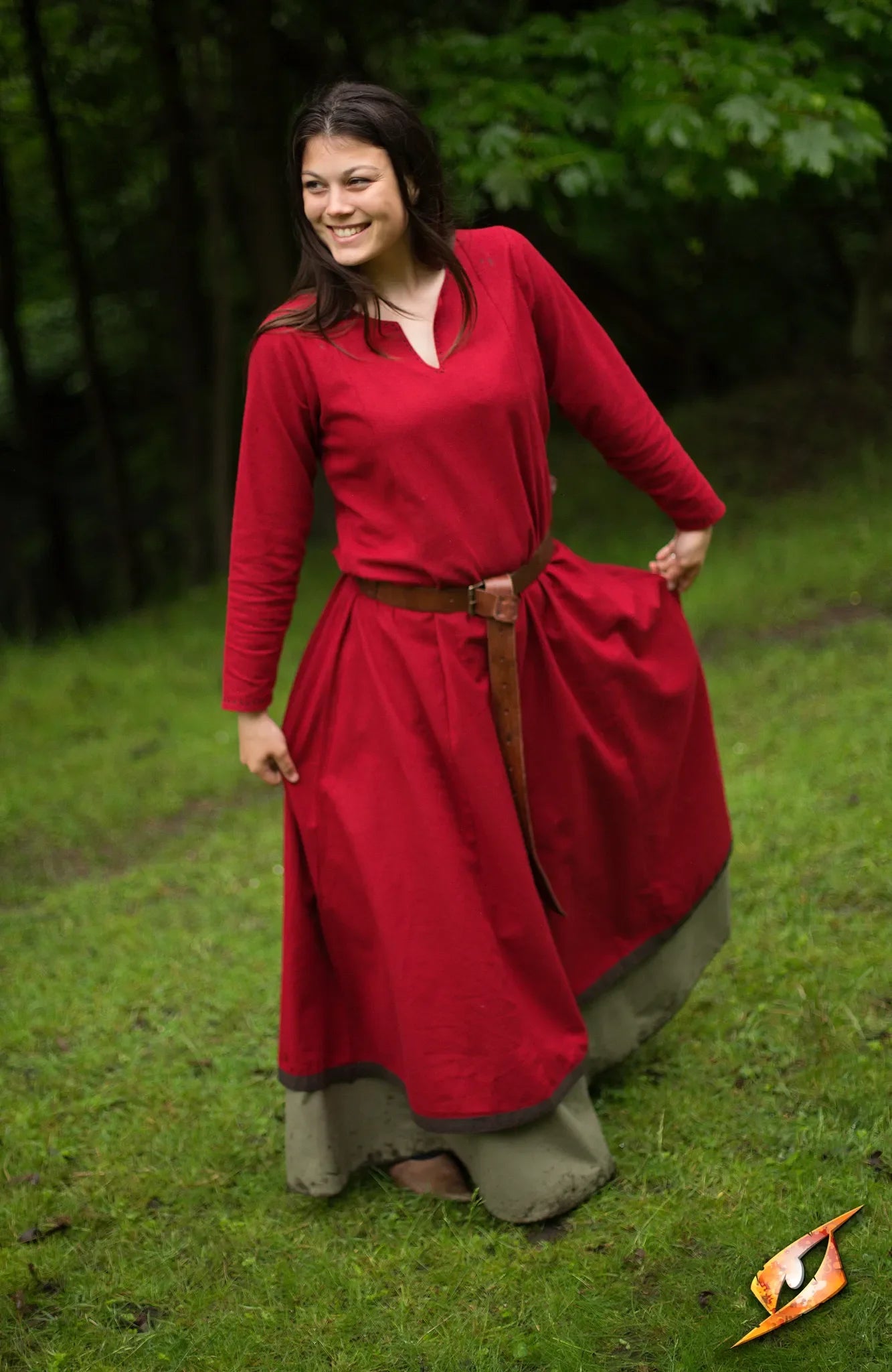 Model wearing a vibrant red Basic Dress with a long skirt in a lush green outdoor setting.
