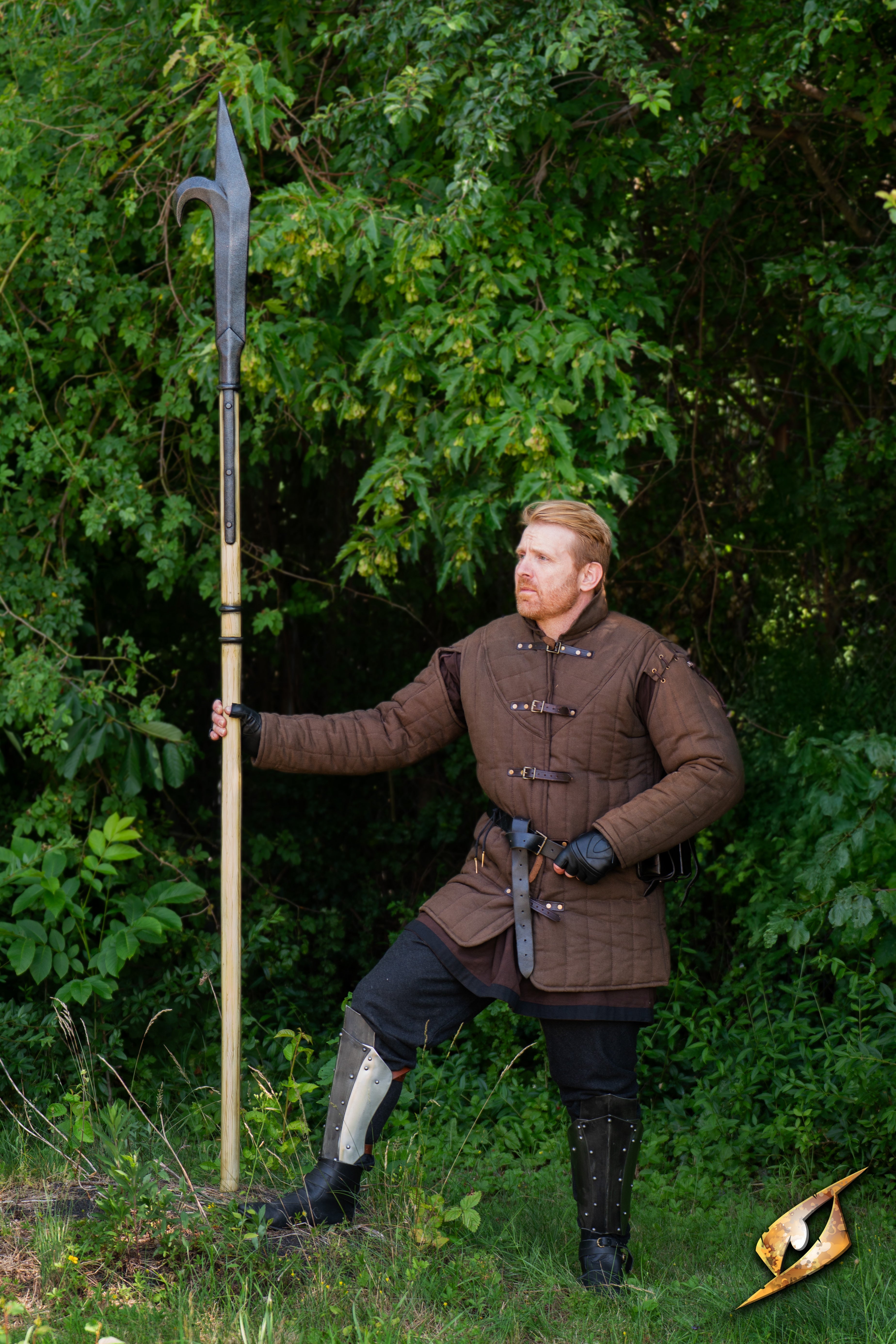 Man holding a Bill Hook weapon in a forest setting, showcasing its design and versatility for battlefield strategy.