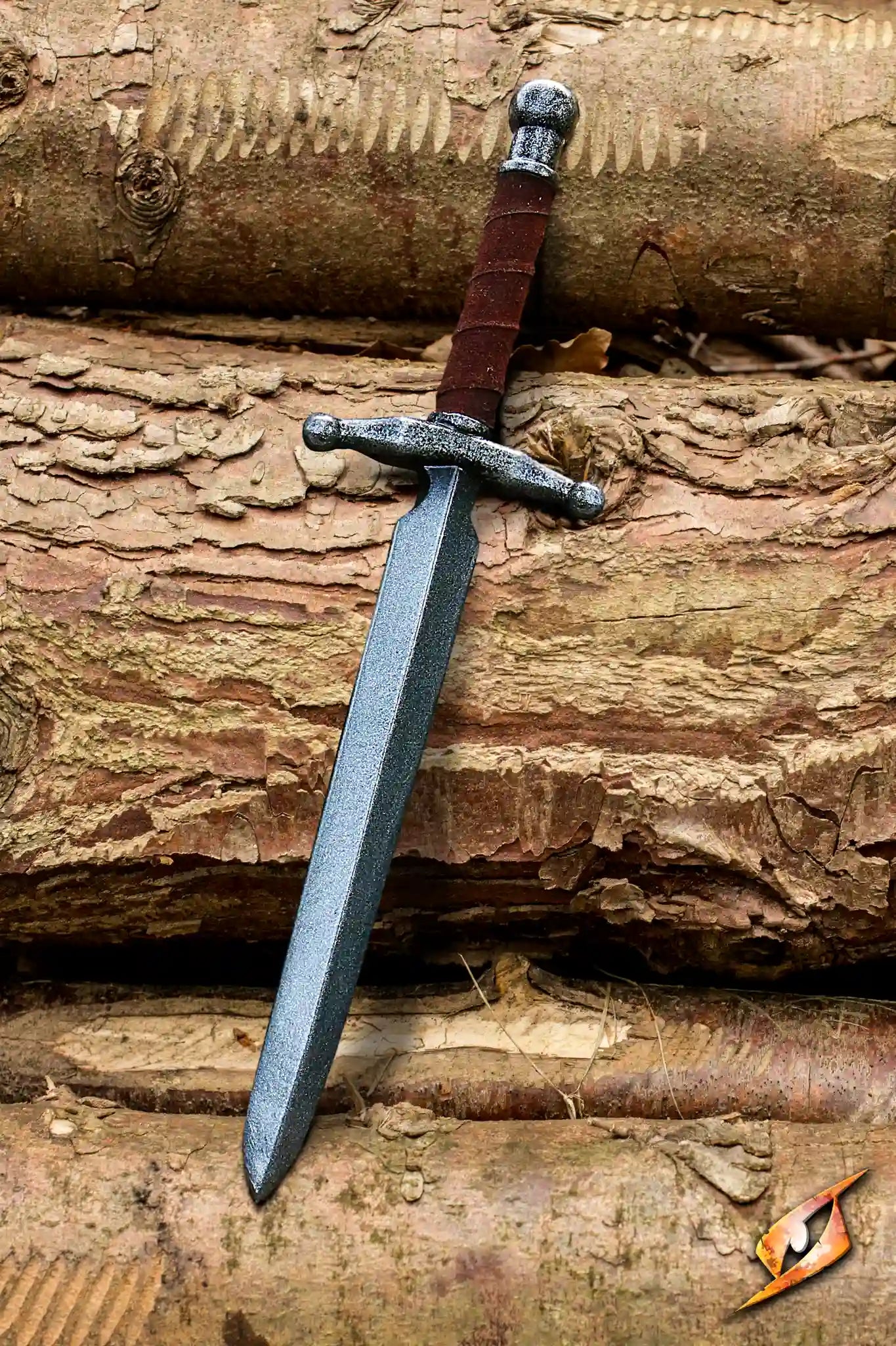 Stiletto - 47 cm displayed on textured wooden logs, showcasing its sharp blade and ornate hilt.