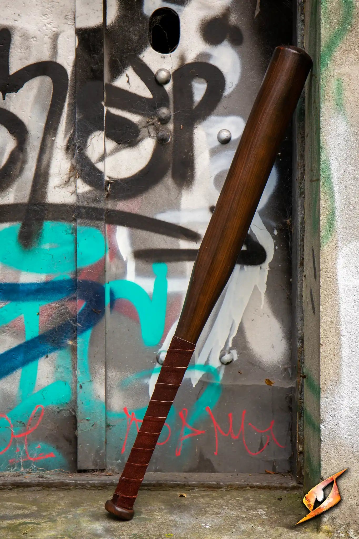 Baseball Bat leaning against a graffiti-covered door in an abandoned setting.