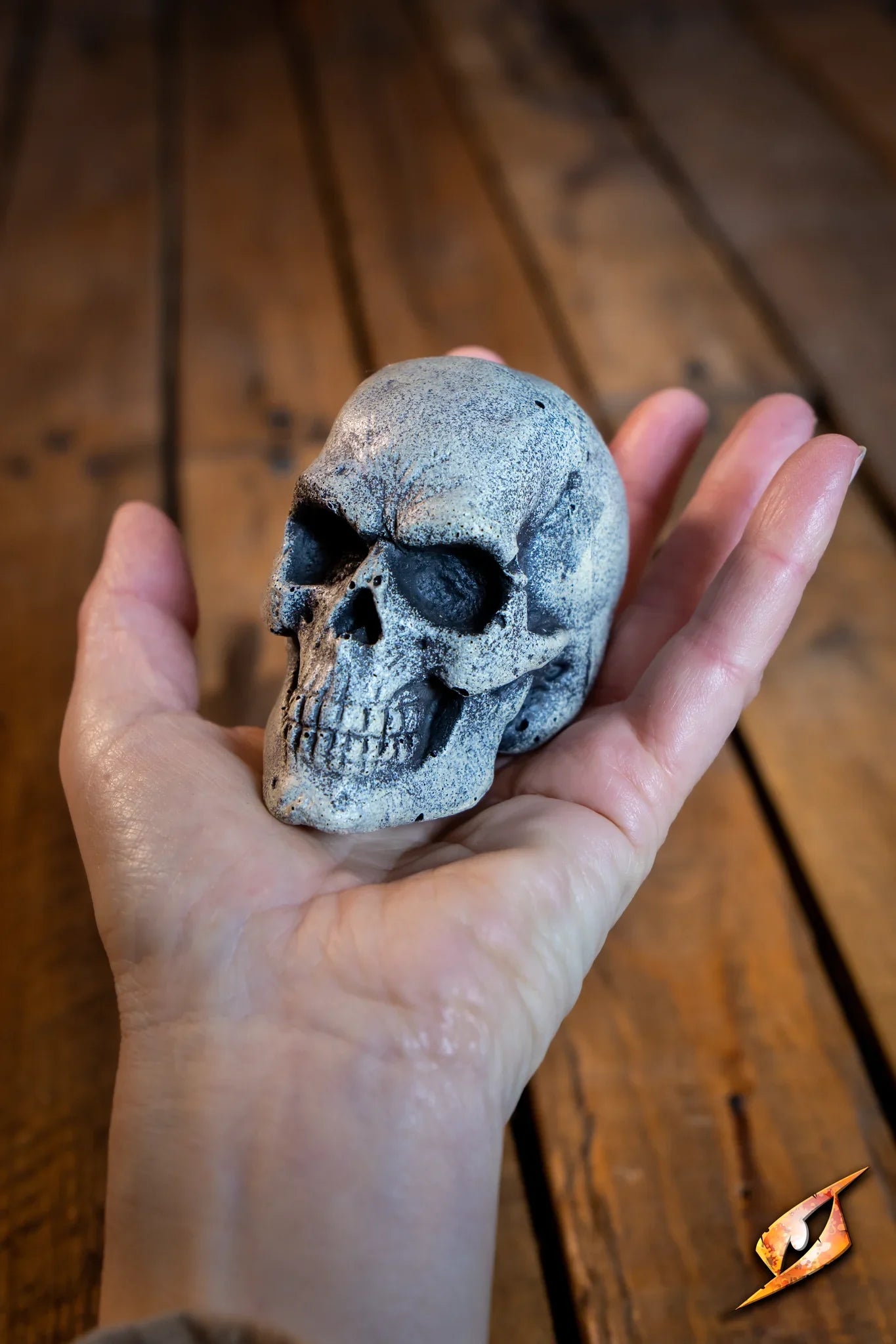 Hand holding a Small Skull, a powerful focus for spellcasting by orc shamans.