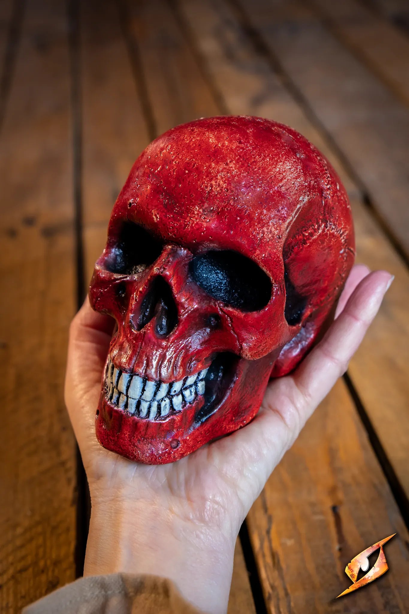 Medium Skull held in hand, featuring vibrant red color and intricate detailing, perfect for necromancer-themed decor.