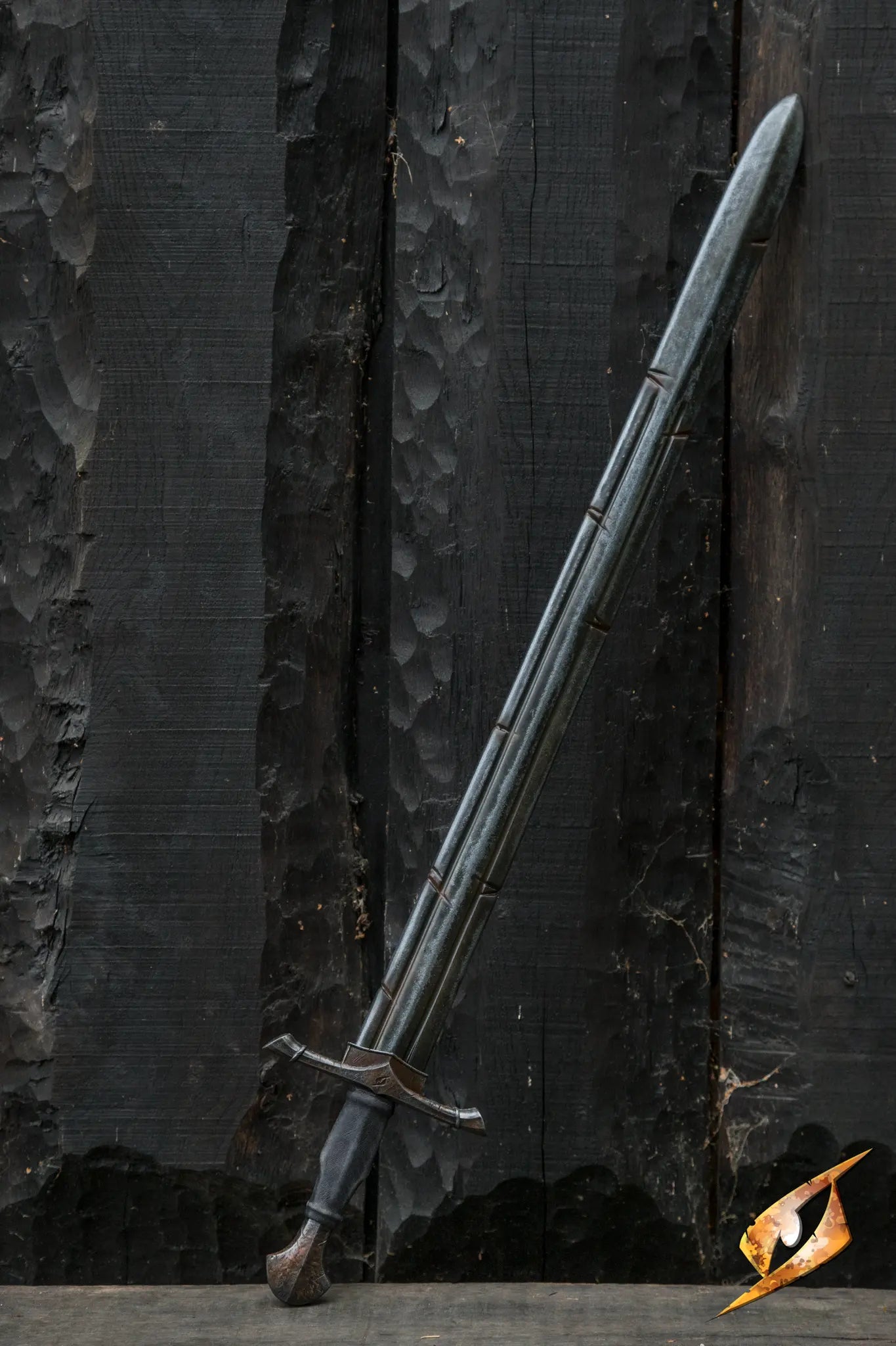 Battleworn Ranger Sword leaning against a textured black wooden background, showcasing its battle-worn features.