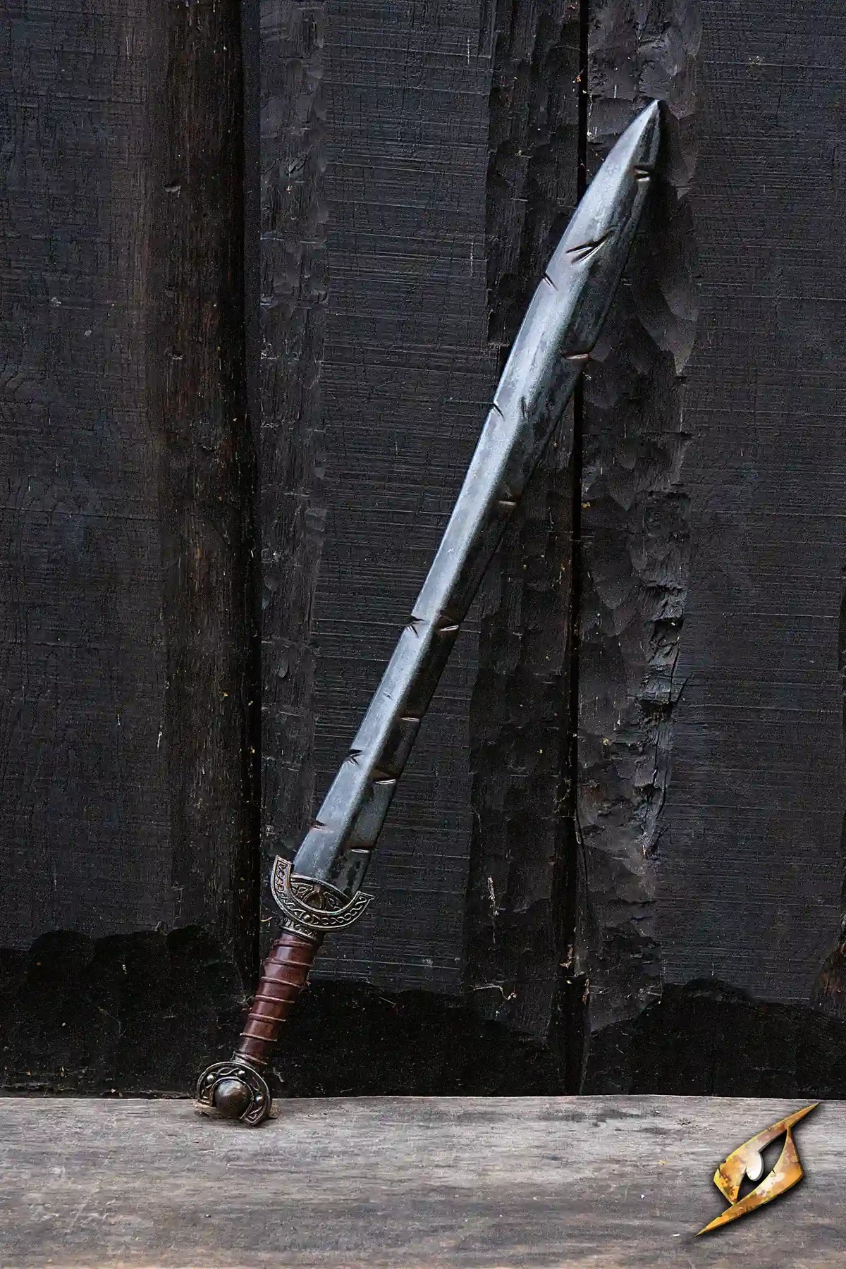 Battleworn Celtic Leaf Sword displayed against a rustic wooden background, showcasing its aged, battle-worn details.