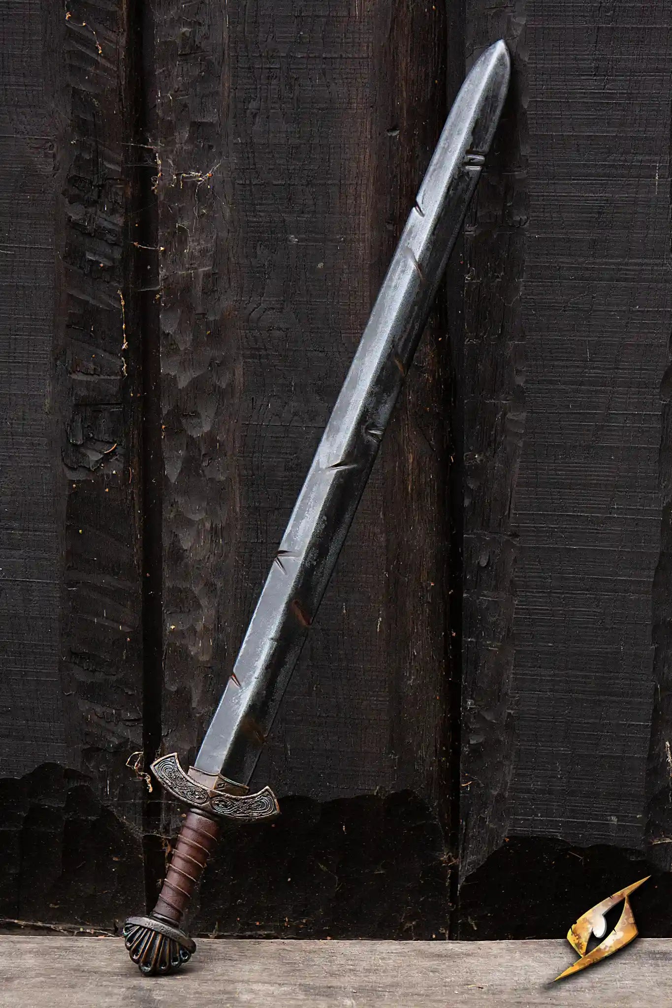 Battleworn Viking Sword displayed against a dark wooden background, showcasing its intricate design and battle-worn appearance.