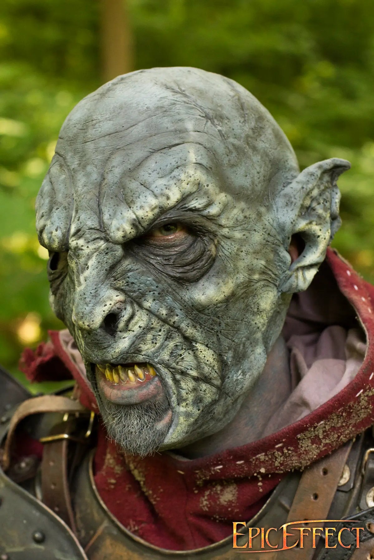 Close-up of a Beastial Orc character, showcasing intricate makeup and fierce expression in a forest setting.