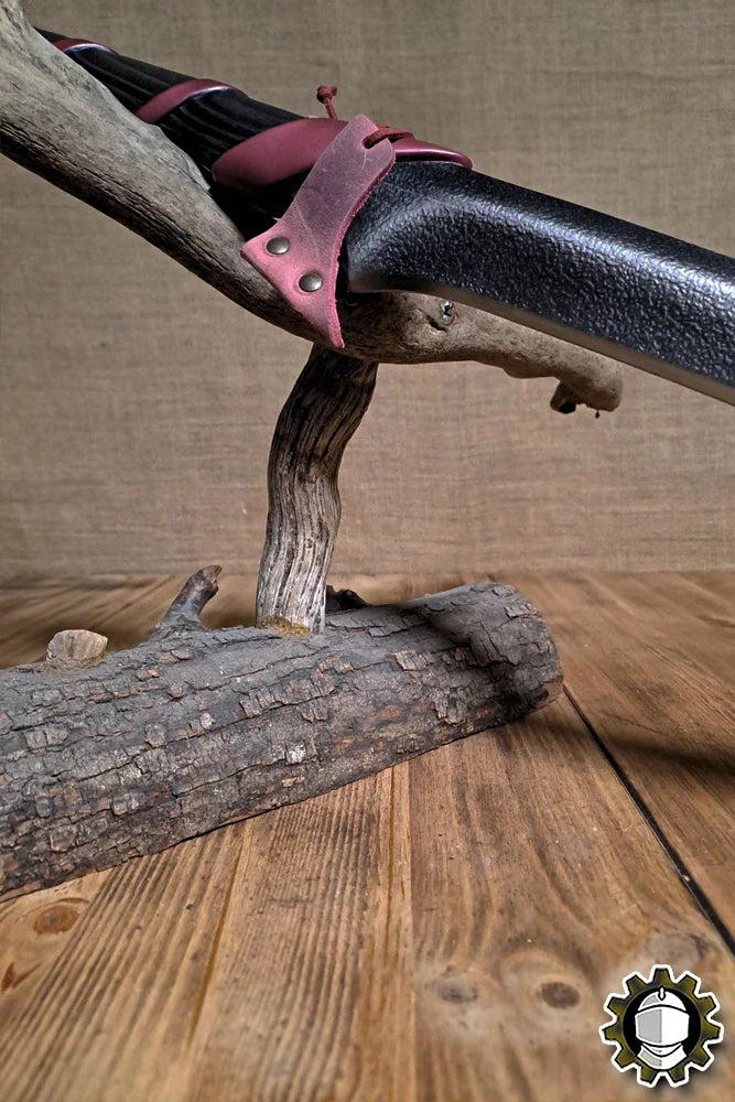 Blade Hook (New Blood) securing a weapon grip on a rustic wooden stand.