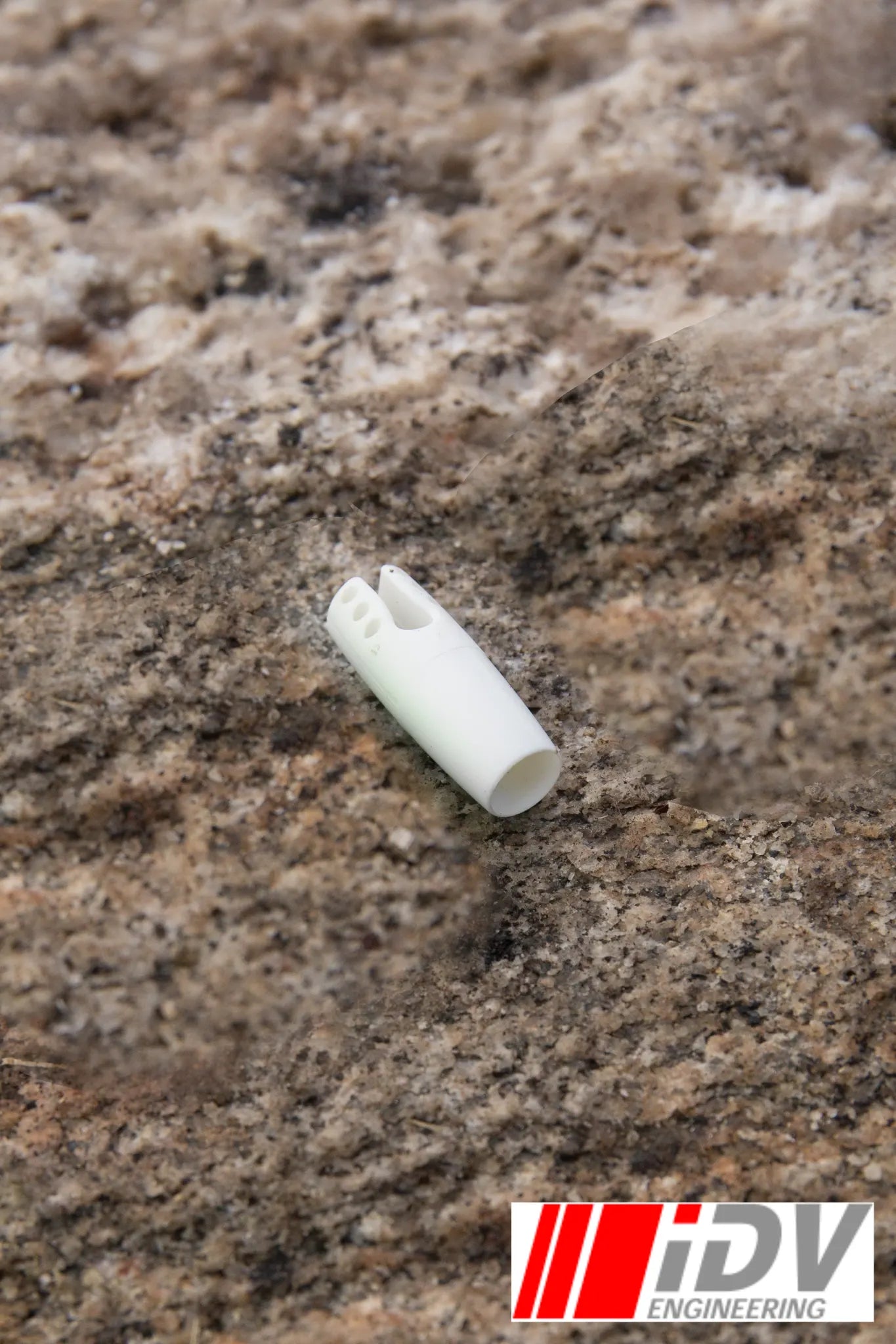 Nock for Larp Arrows in white color resting on rocky surface, designed by iDV Engineering for archery enthusiasts.