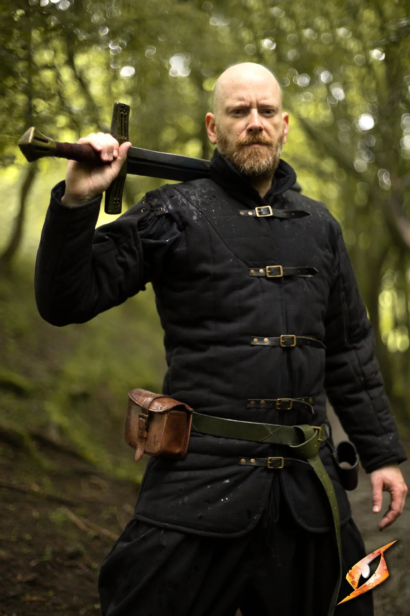 Gambeson Warrior With Long Sleeves standing confidently in a forest, holding a sword, exuding power and fear.