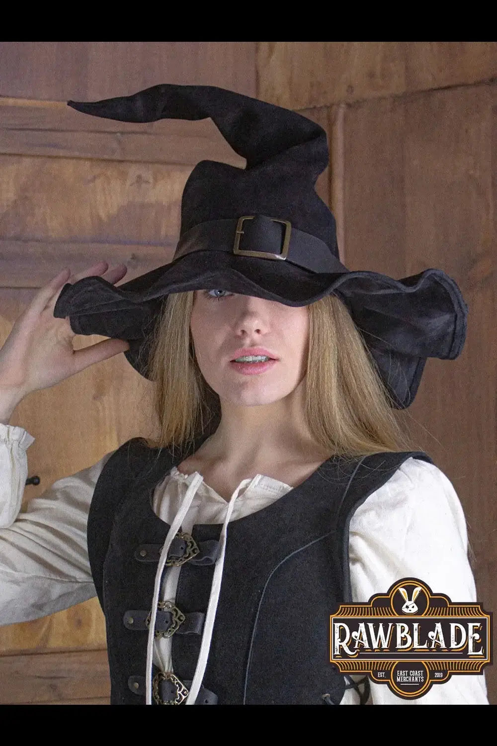 Wikka The Witch Hat Split Leather worn by a model, featuring a pointed design and black leather finish.